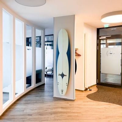 Surfbrettdekoration in der Zahnarztpraxis Heitmüller, Hannover List, mit Glasfront, Surfbrett-Dekoration und modernem Interieur.